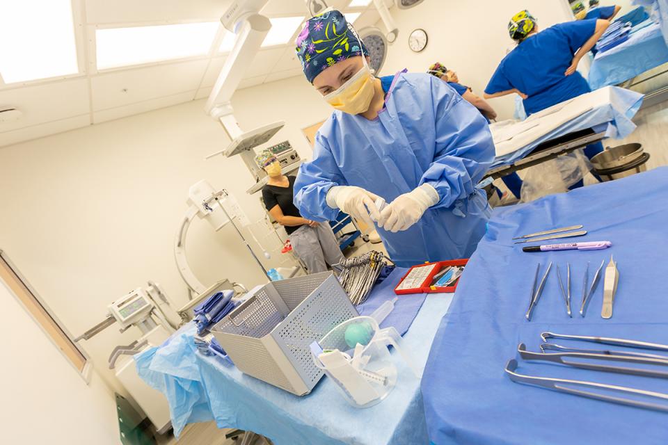 A student practices preparing instruments for surgery.