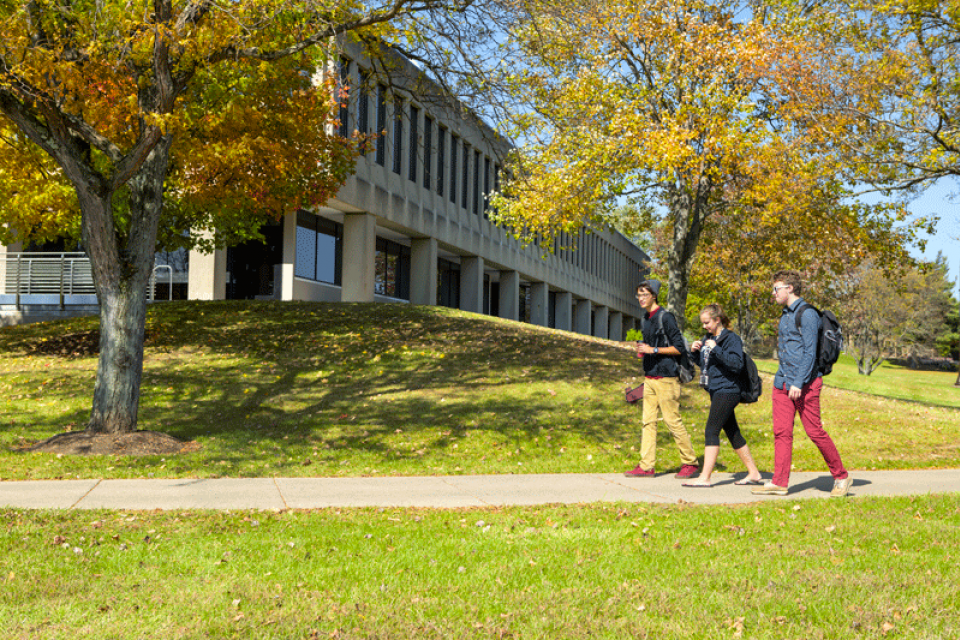 Three students walking across campus