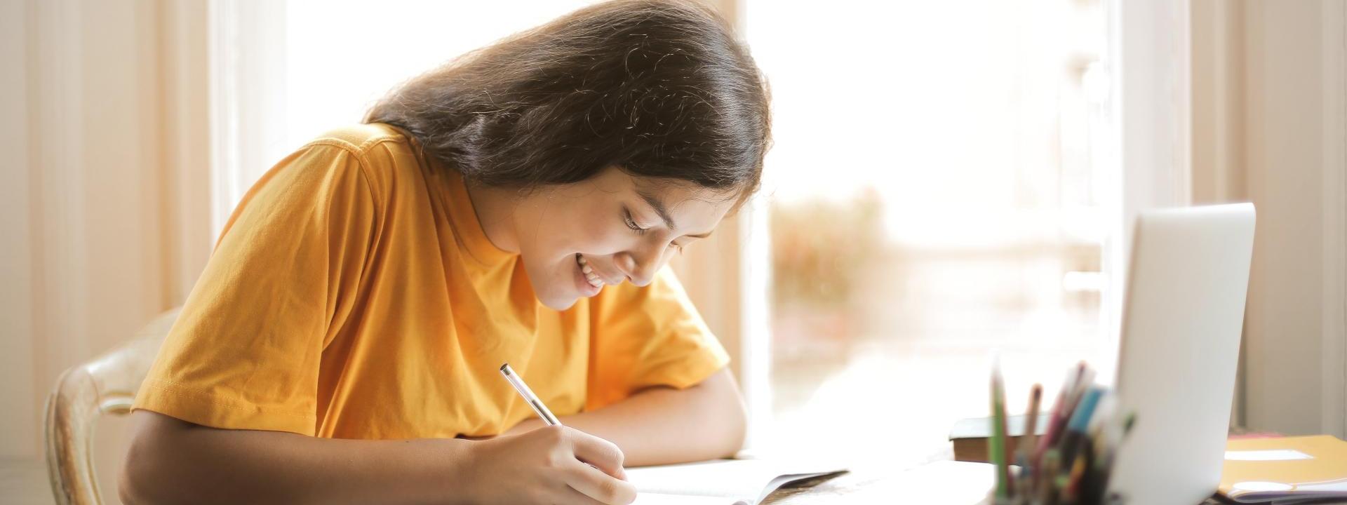 Student sitting at computer filling out paperwork