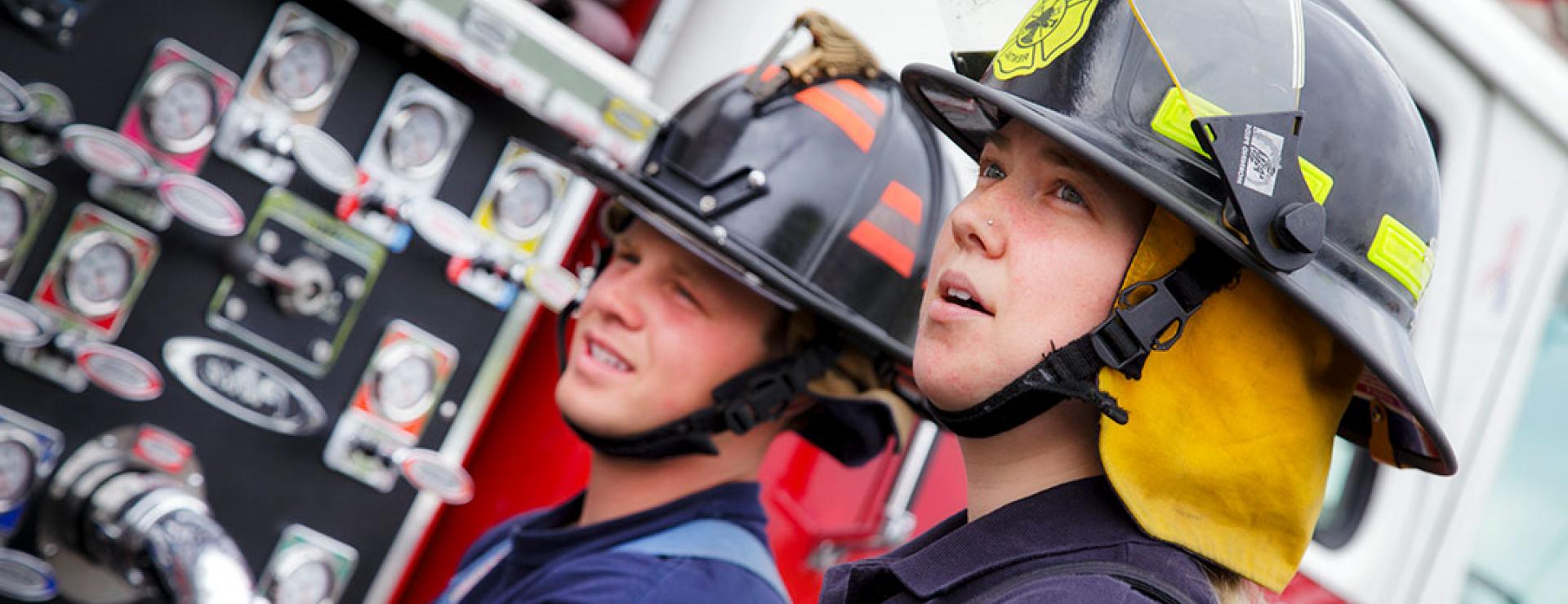 two Fire students standing at truck