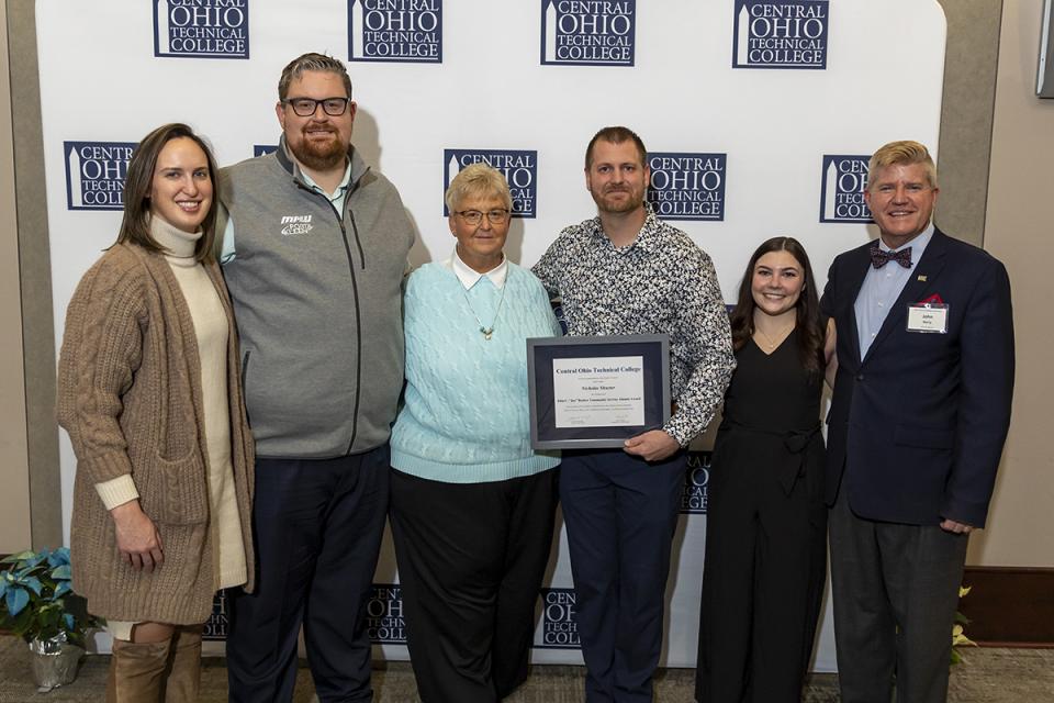 Portrait of Nick Shuster with his family, the Barker family and COTC President John Berry.