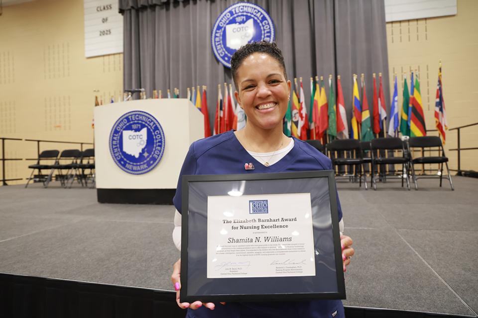 Shamita Williams holds an framed certificate announcing her receipt of the Barnhart Award for nurses.