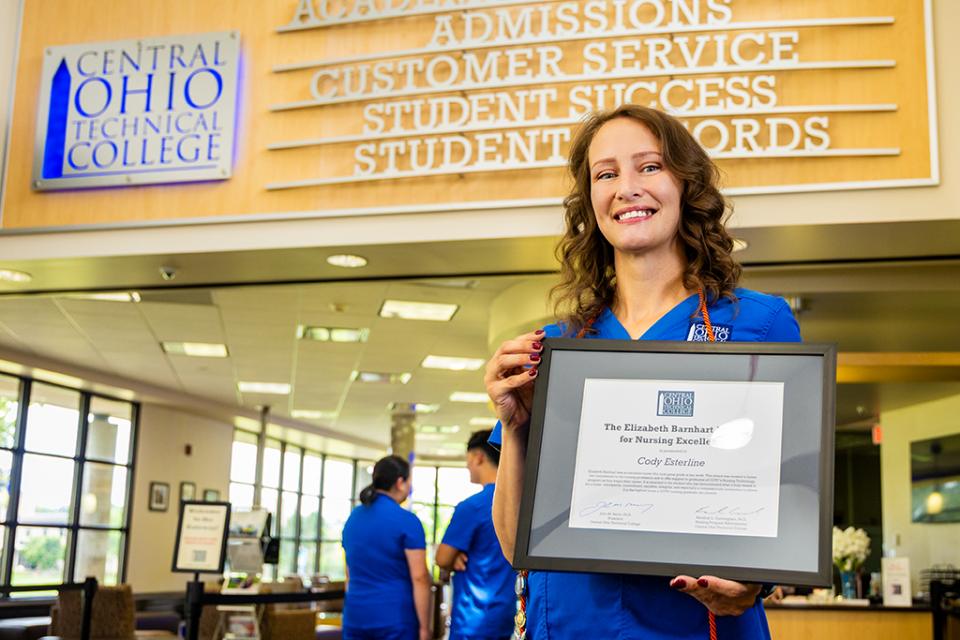 Cody Esterline holds her framed award certificate.