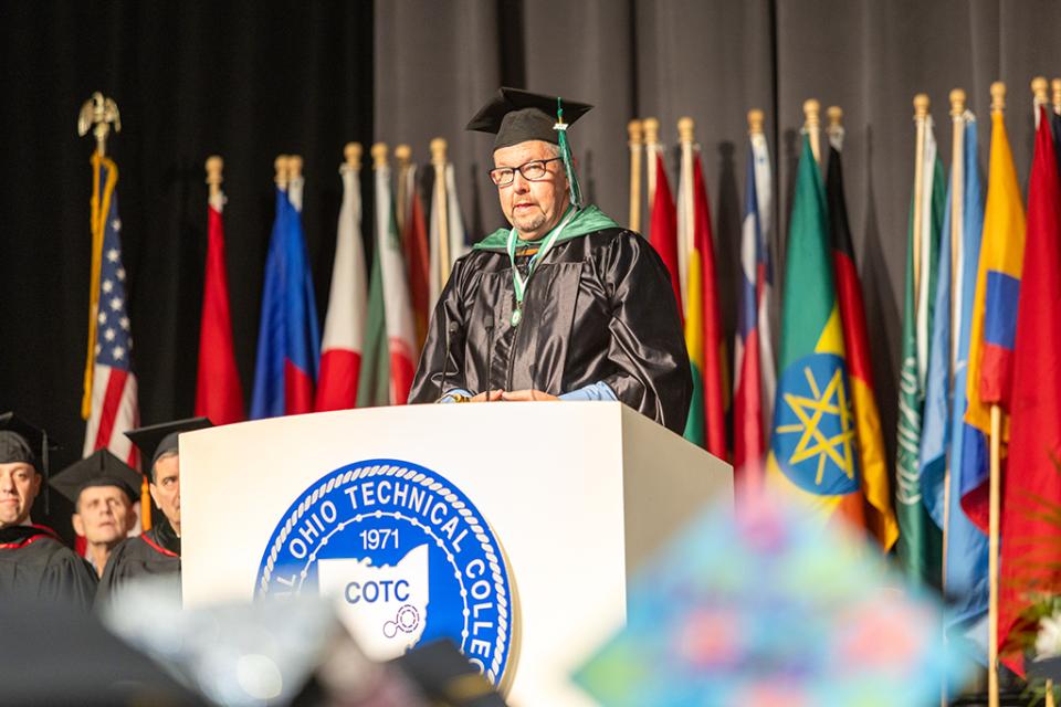 Terry Bertiaux Alumni and keynote speaker Terry Bertiaux stands at the podium delivering his address to the graduates and audience.