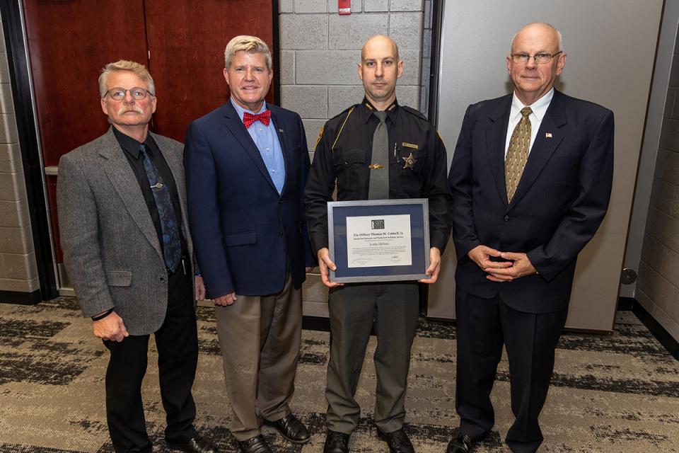 Justin Holmes holds his award certificate standing next to COTC President John Berry and faculty Jeff Sowards and Mark Prince.