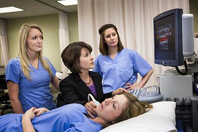 Students performing an ultrasound on a patient