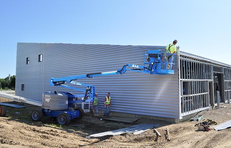 A man on a sky lift working on a building