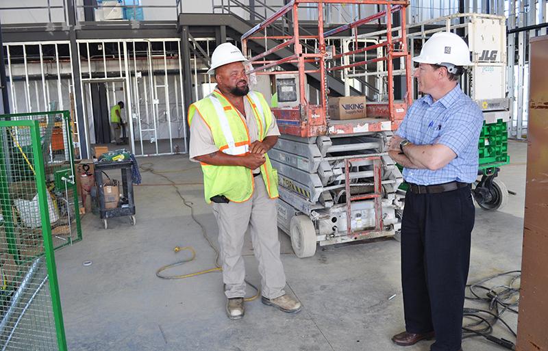 Two constructions workers talking outside the building