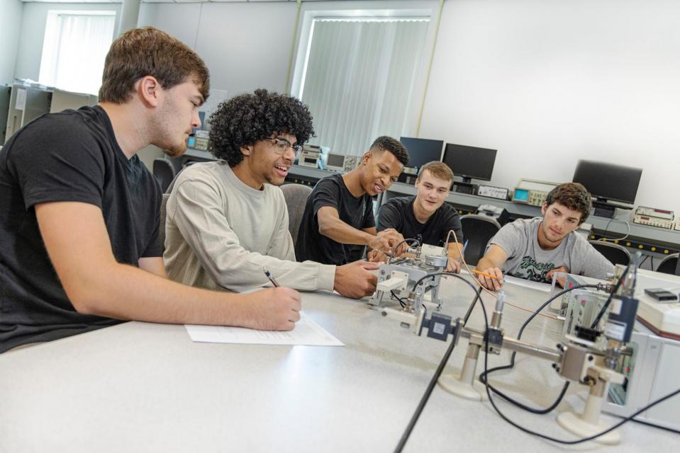 Students in a classroom work on a project together.