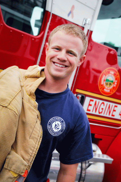 Firefighter posing with jacket draped over his shoulder