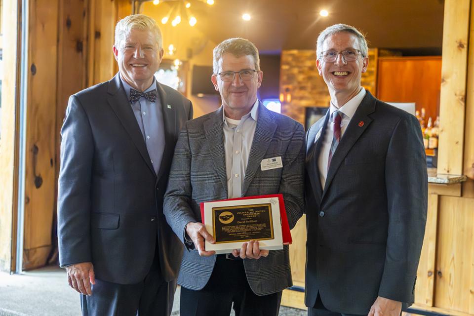 David Brillhart holds the Greenstein Award plaque he received while standing between COTC President John Berry and Ohio State Newark Dean and Director Matthew Smith.
