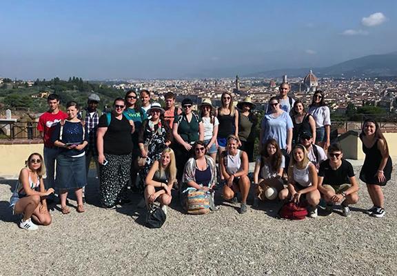 Group of students with Italian city behind them