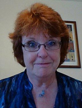 Woman with red hair smiling at camera, COTC Professor Pamela Kirst