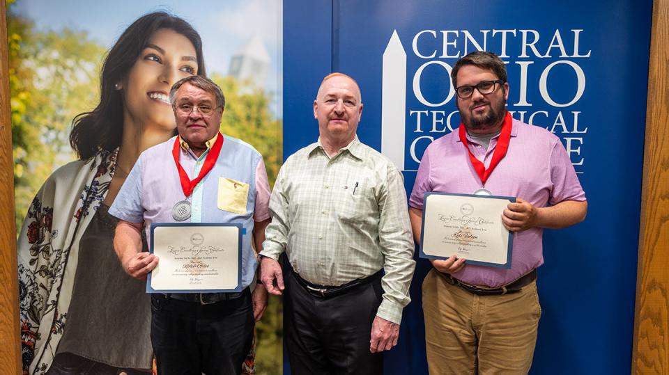 Ralph Giles and Kyle Fulton hold their Excellence Award certificate standing with COTC President John Berry and COTC Provost Greg Ferenchak.