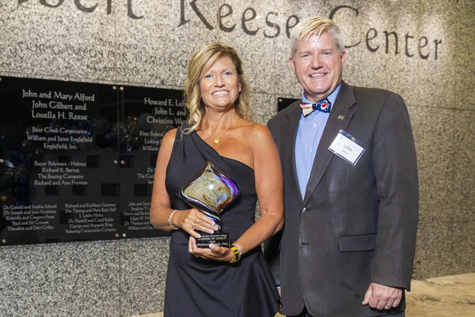 Kim Goudy  stands next to COTC President John Berry holding the Legends of Loyalty award.