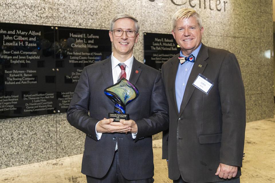 Ohio State Newark Dean and Director Matt Smith stands next to COTC President John Berry holding the Legends of Loyalty award for Ohio State Newark.