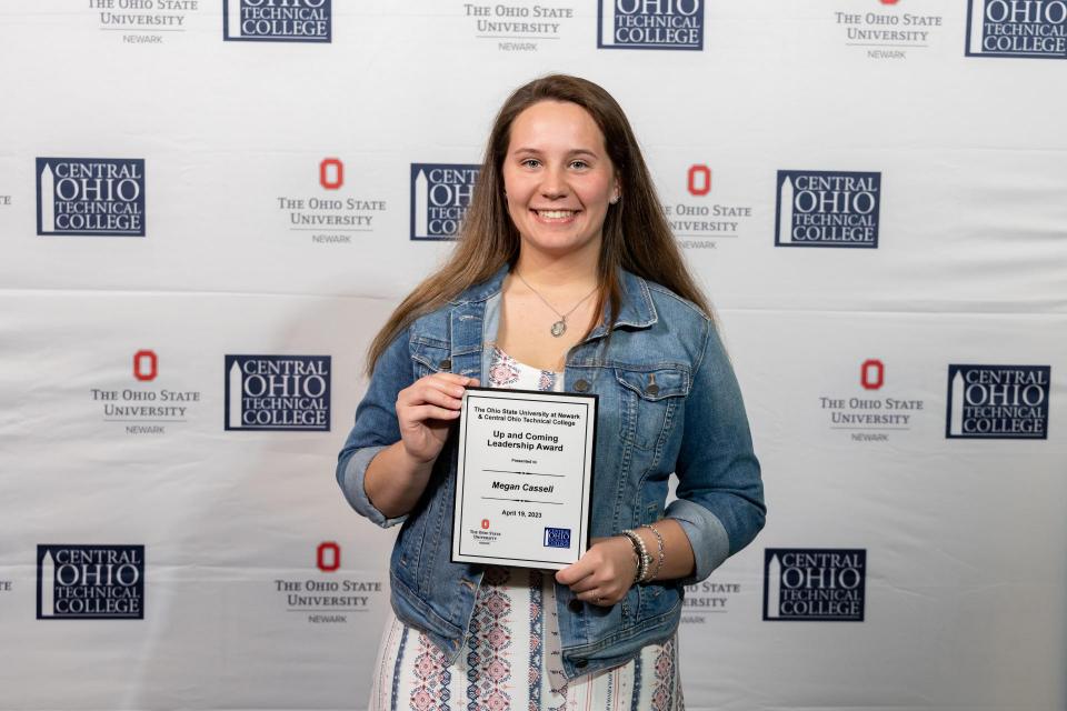 Megan Cassell holds her certificate for the Up and Coming Leadership Award.