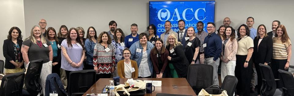 COTC staff members Eric Veigel (second from right) and Amanda Snider (third from right) pose alongside this year's entire OACC Leadership Academy cohort. A group of people stand together in a classroom.