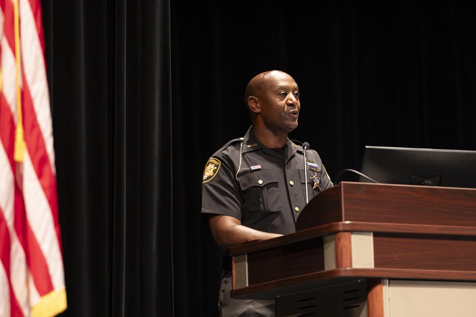 Ira Daniels stands at a podium speaking to the audience at the May 21, 2026 Peace Officer Basic Training program graduation at COTC.