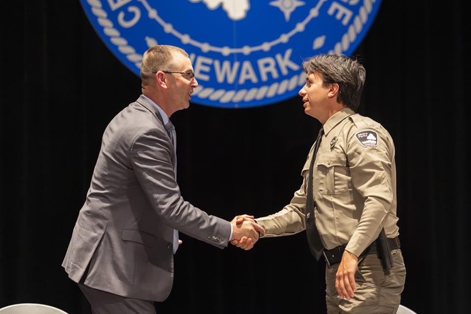 State Representative Kevin Miller and graduate State Representative Kevin Miller shakes hands with a COTC Peace Officer Basic Training graduate during the May 21, 2026 ceremony.