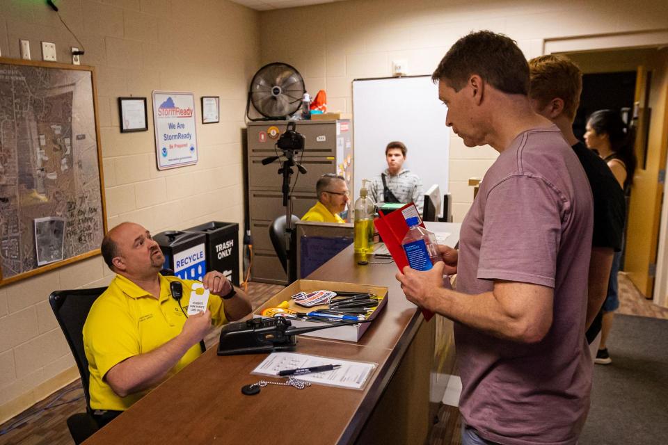 A student gets a parking permit from a security officer while another one gets his photo taken for a student ID.