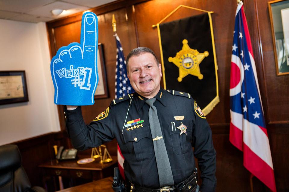 Sheriff Randy Thorp in uniform holding a blue number one foam finger