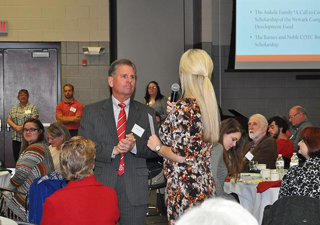 A woman speaking to a man at the scholarship breakfast