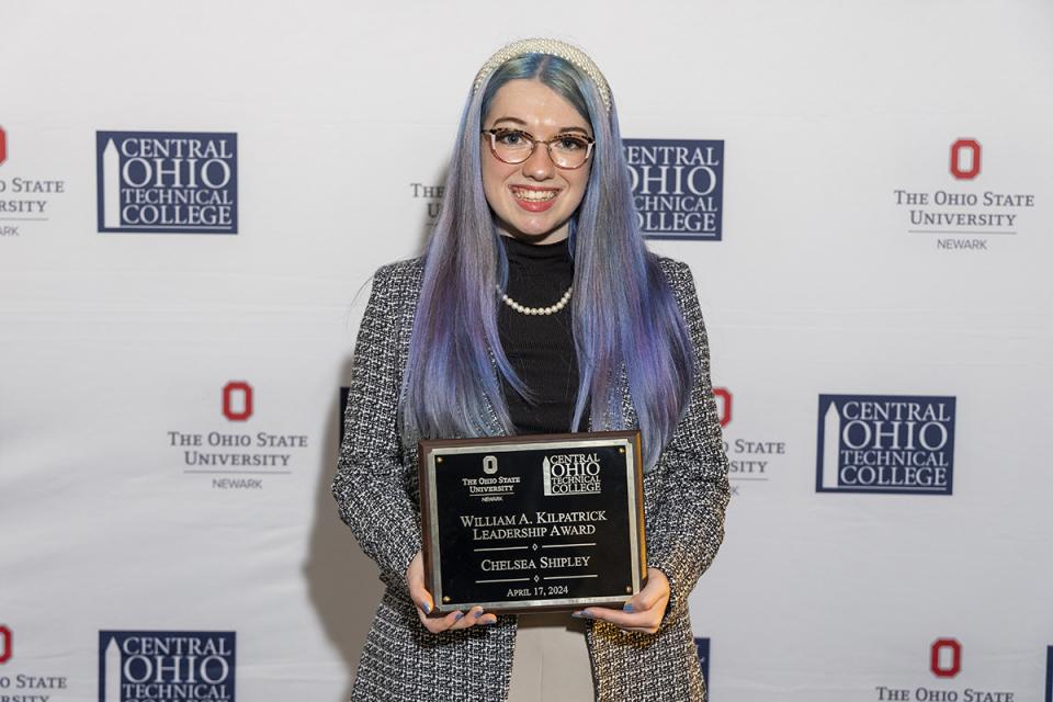 Chelsea Shipley holds a plaque recognizing her receipt of the William A. Kilpatrick Leadership Award.