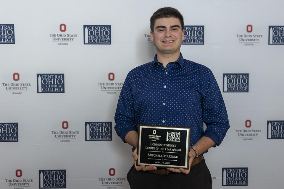 Portrait of Mitchell Mazzone holding his award certificate. 