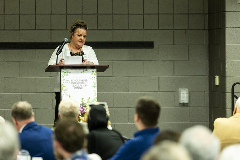Megan Connell-Cox stands at a podium delivering a speech.