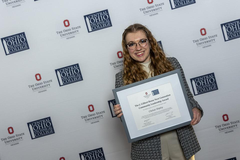 Picture of Chelsea Shipley holding their award certificate.