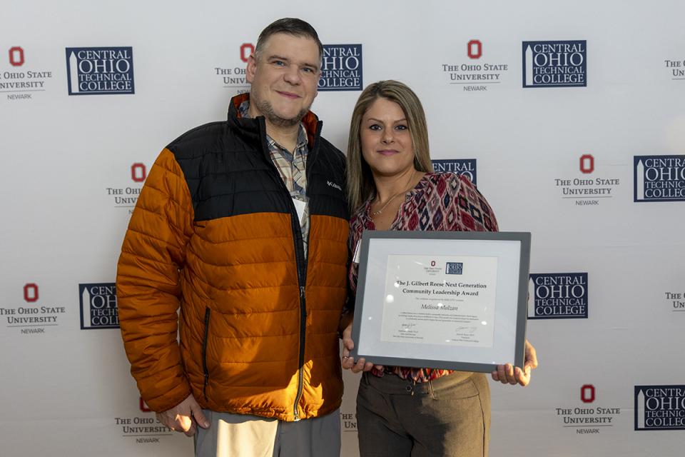 Portrait of Melissa Molzan holding their award certificate.