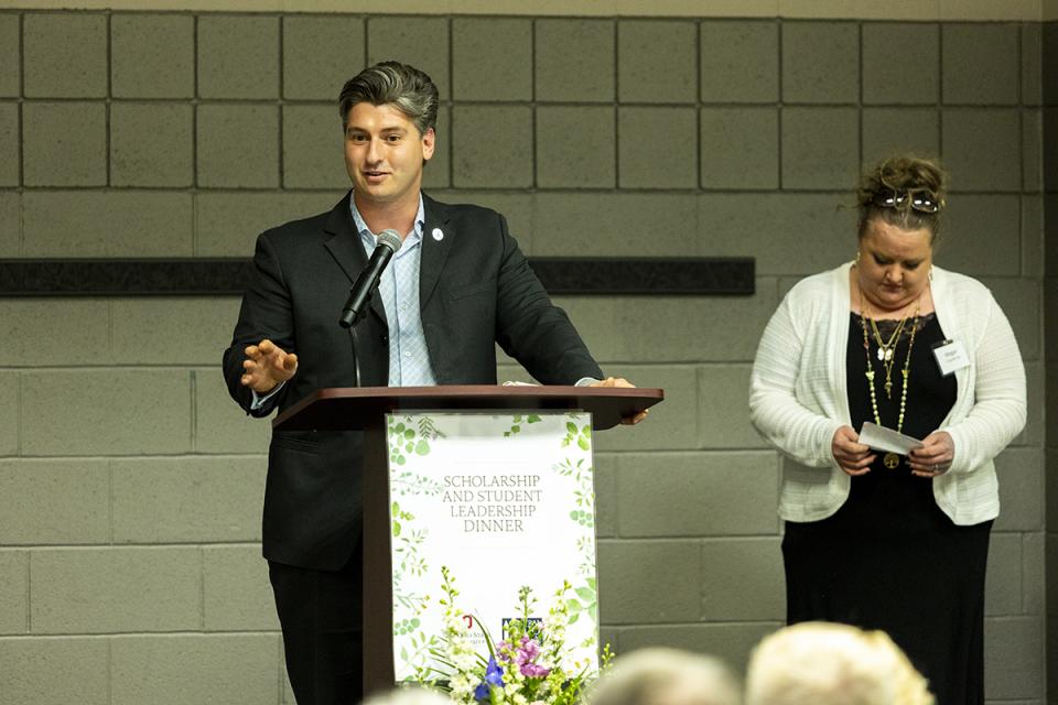 Trace Johnson stands at a podium delivering a speech.