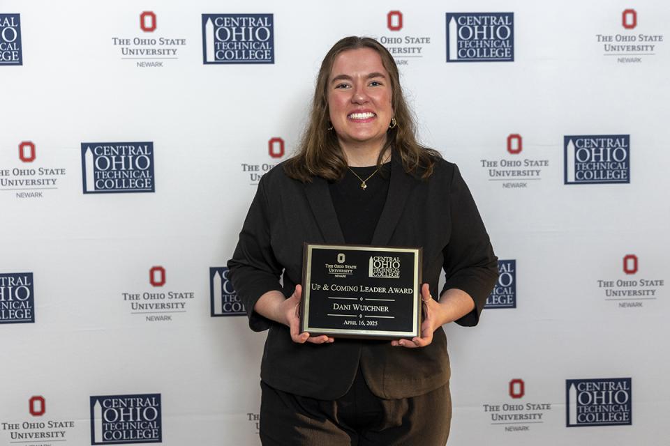 Portrait of Dani Wuichner holding their award plaque.