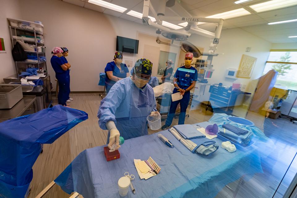 A student prepares instruments for surgery.