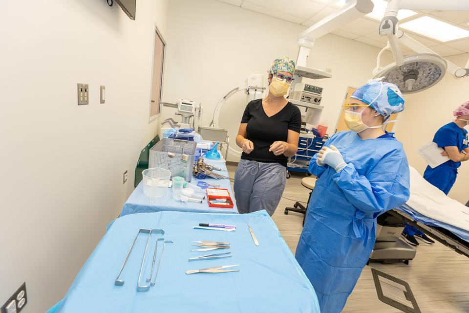 An instructor and student prepare instruments for surger.