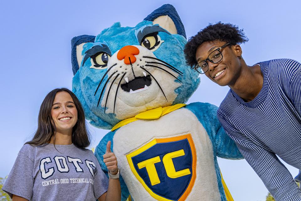 Two students stand on either side of TC smiling