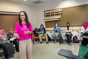 Female African-American Professor smiling in front of class