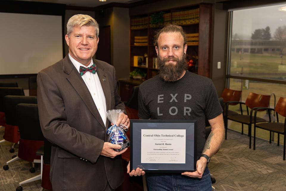 COTC President John Berry stands next to Garrett Martin who is holding a framed certificate. 