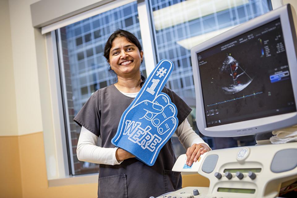 Archana Rajendran standing next to ultrasound machine. 