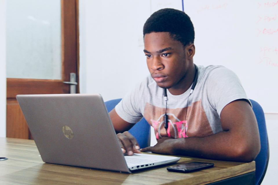 Young man sitting and looking at laptop