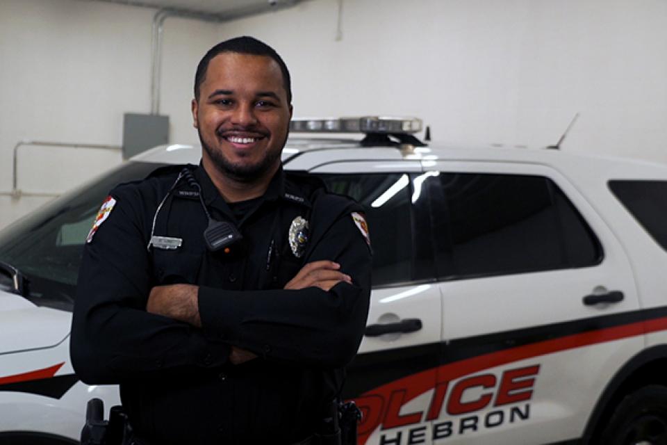 DeLane King standing in front of police cruiser. 