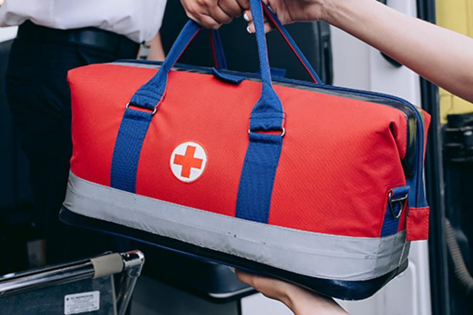 Emergency bag being handed from one  technician to another