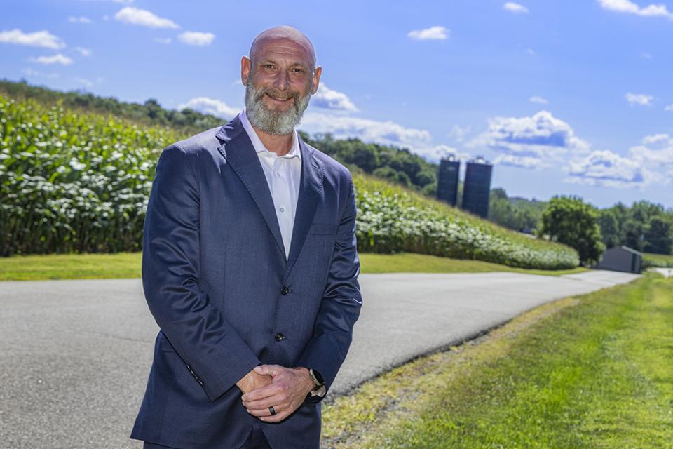 James Golden stands along a country road with cornfield behind him.