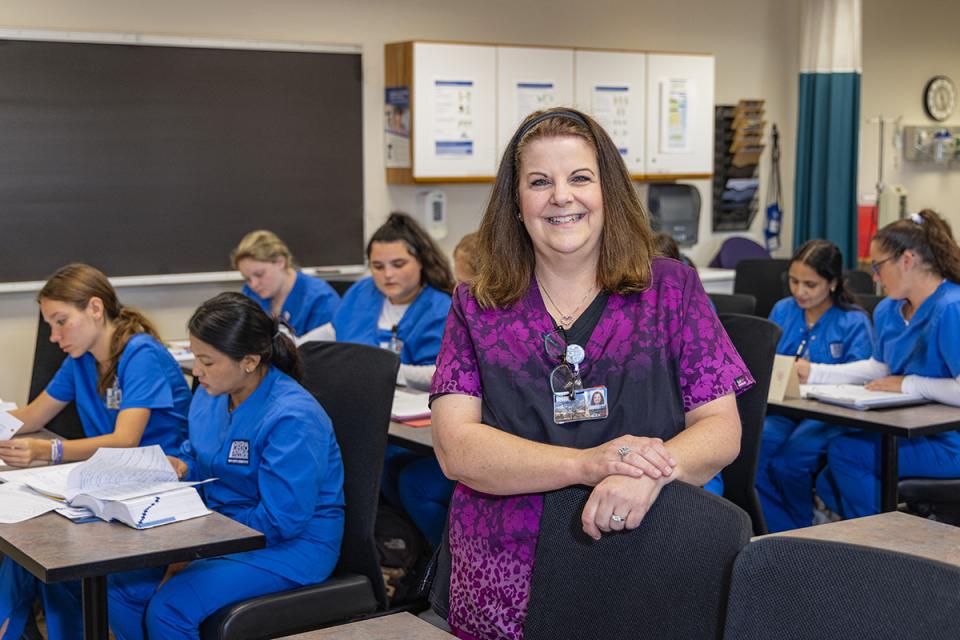Assistant Professor Karen Cooperider stands in a classroom full of nursing students.