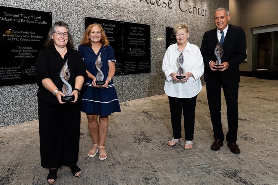 Jennifer Roberts (Newark Campus Development Fund); Jacqueline Parrill, EdD; Sandra Walker, EJD; and Andrea Tozzi Jennifer Roberts; Jacqueline Parrill, EdD; Sandra Walker EJD; and Andrea Tozzi stand in a line holding their Legends of Loyalty award trophies in the lobby of the Reese Center.