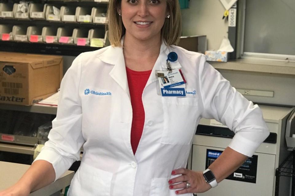 Woman in lab coat smiling at camera