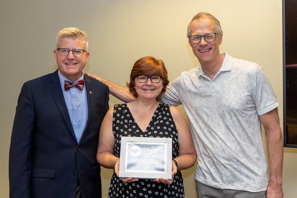 Laura Walsh holds her award certificate while standing between John Berry and William MacDonald.