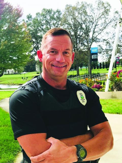 Portrait of George Clark on campus wearing police academy shirt. 