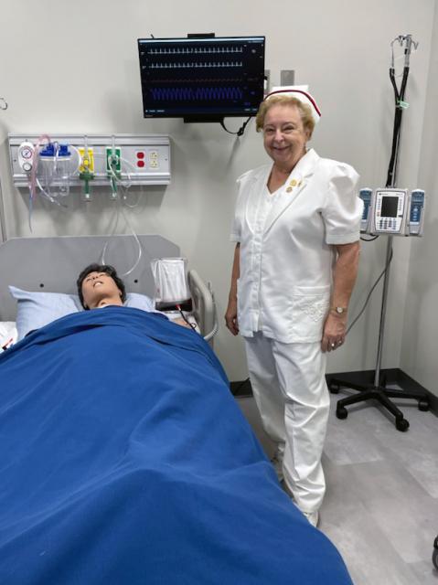 Sherry Engle stands next to a mannequin in a nursing lab at COTC's Pataskala campus. 